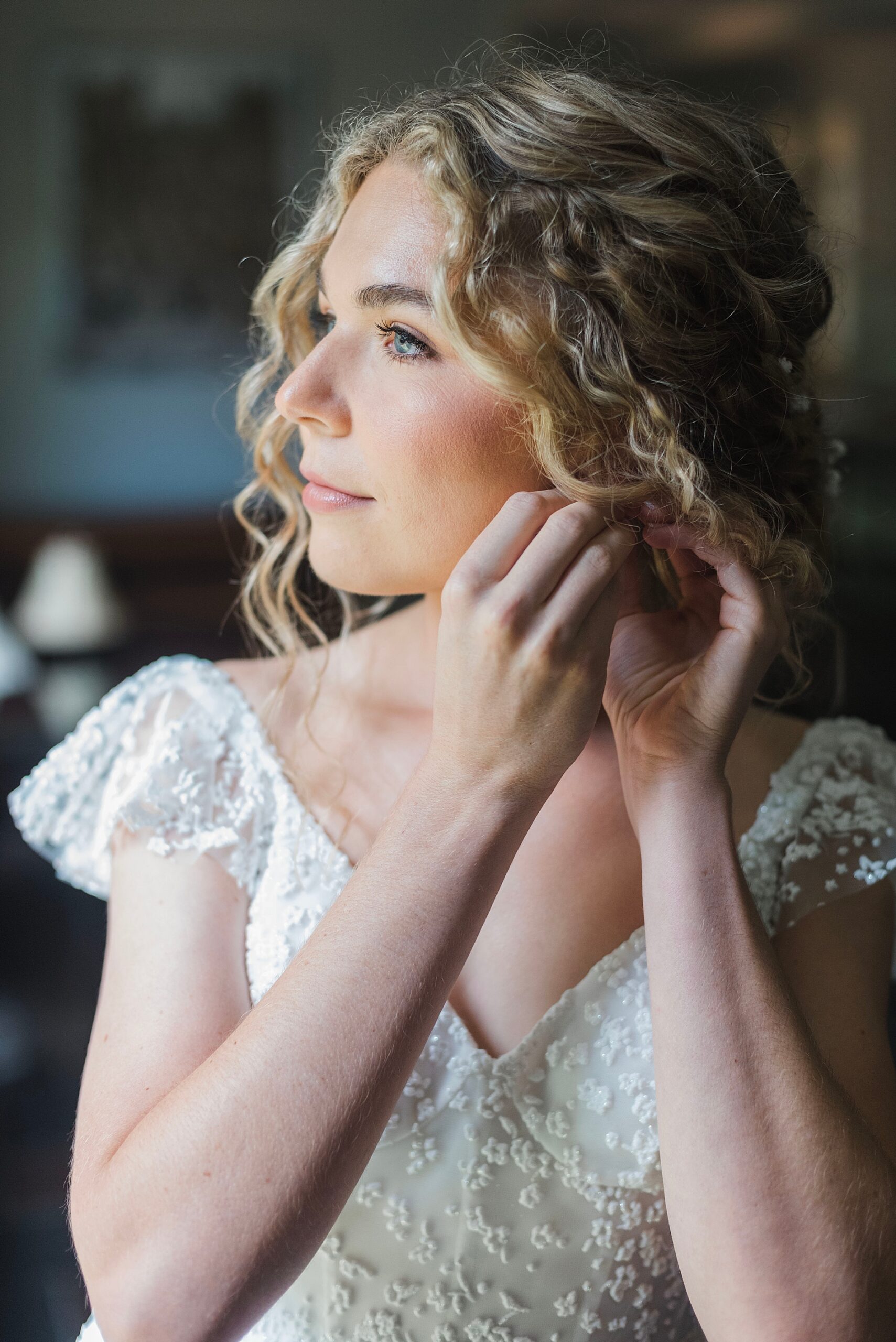 bride putting earrings in 