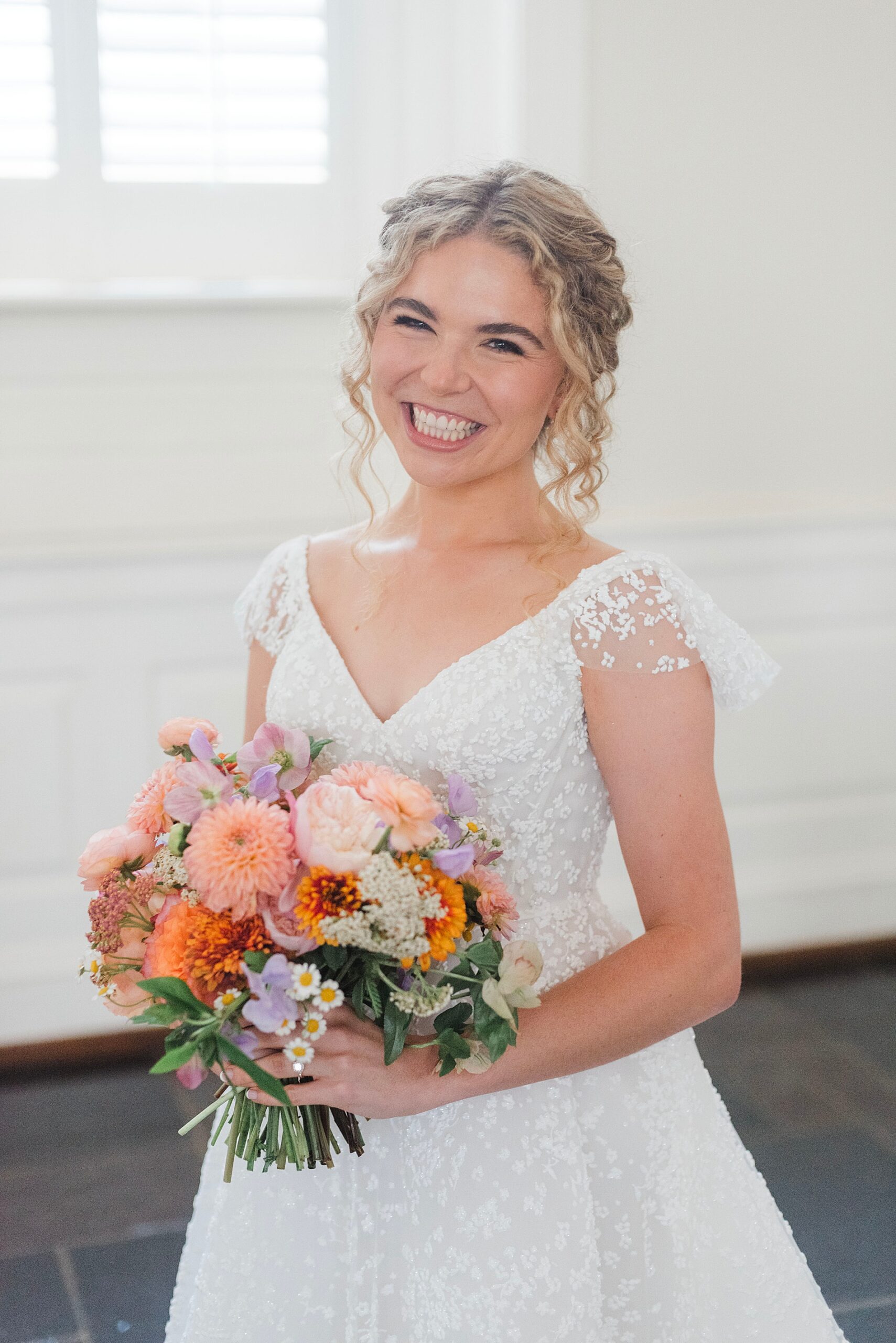 bride holds beautiful bridal bouquet with pops of color 