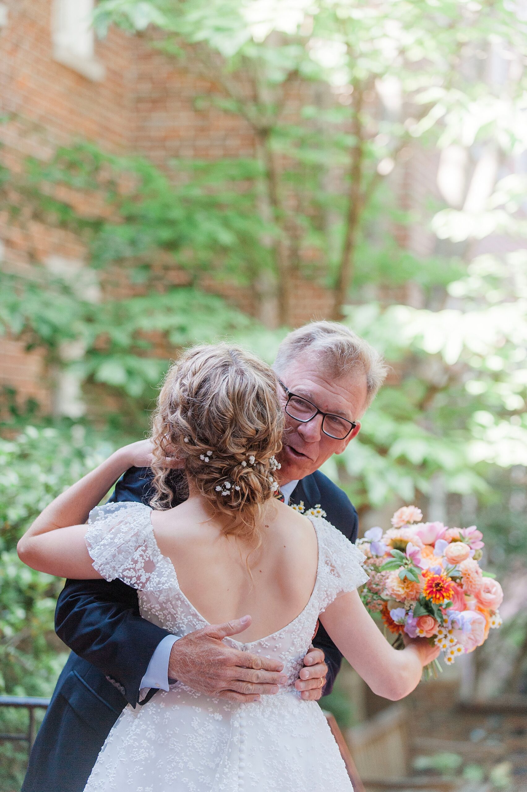 father hugs daughter during first look