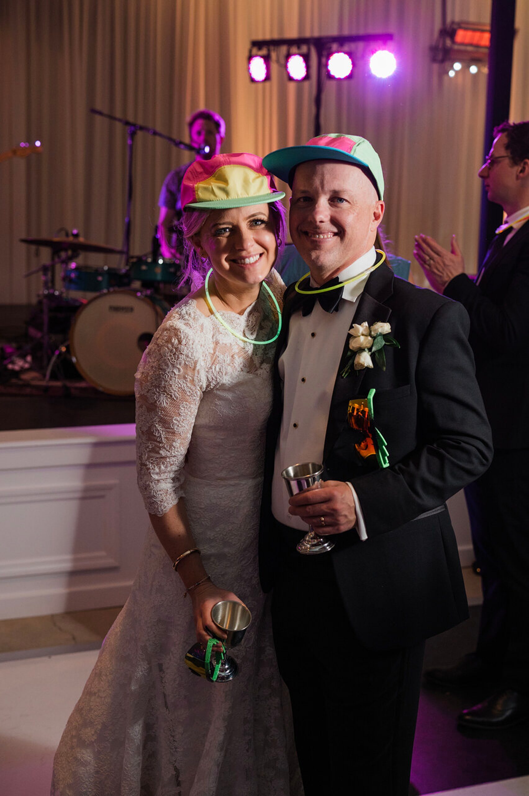 newlyweds celebrate on dance floor with glow sticks and props