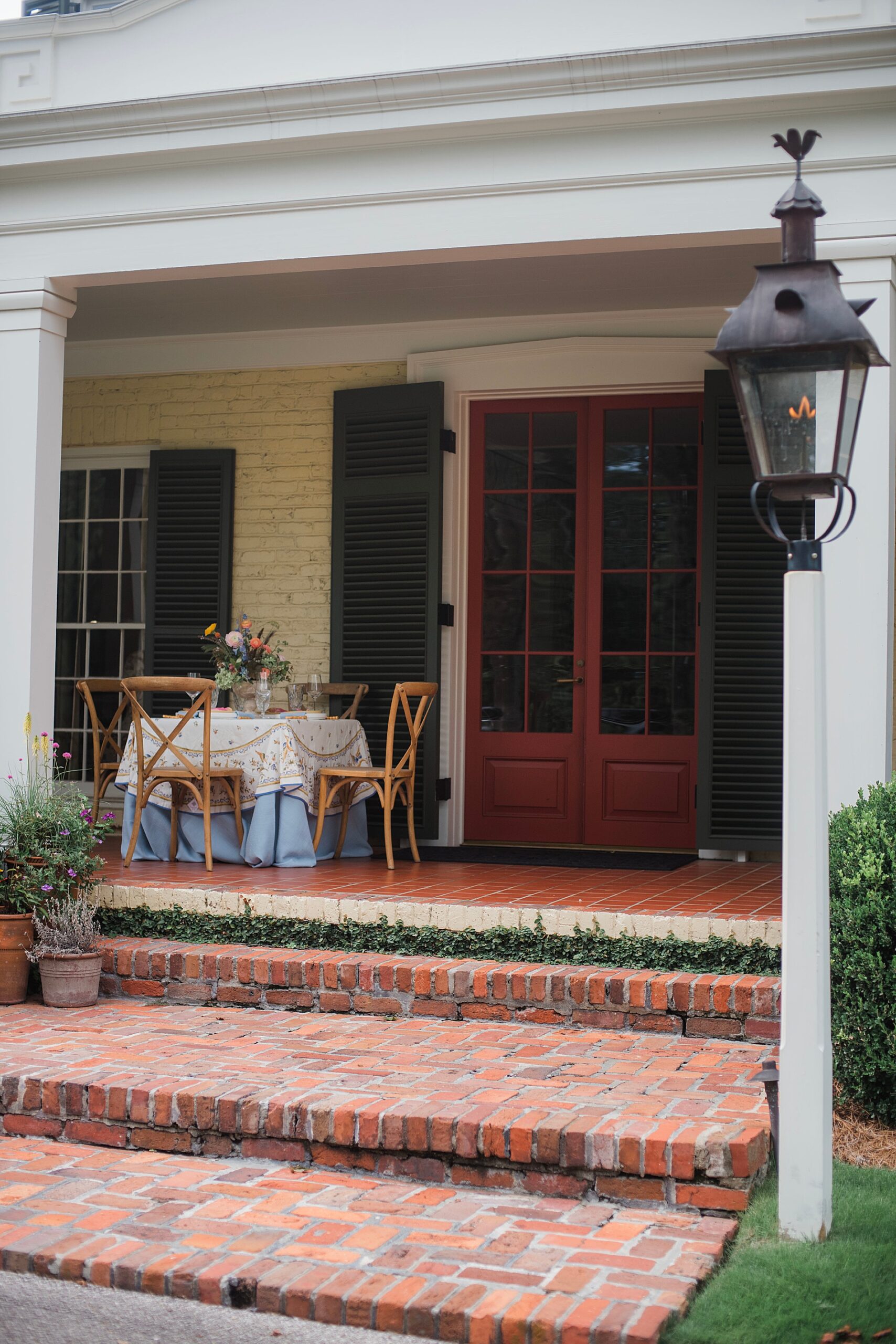 steps leading to front porch where tables are set up for elegant bridal brunch celebration.