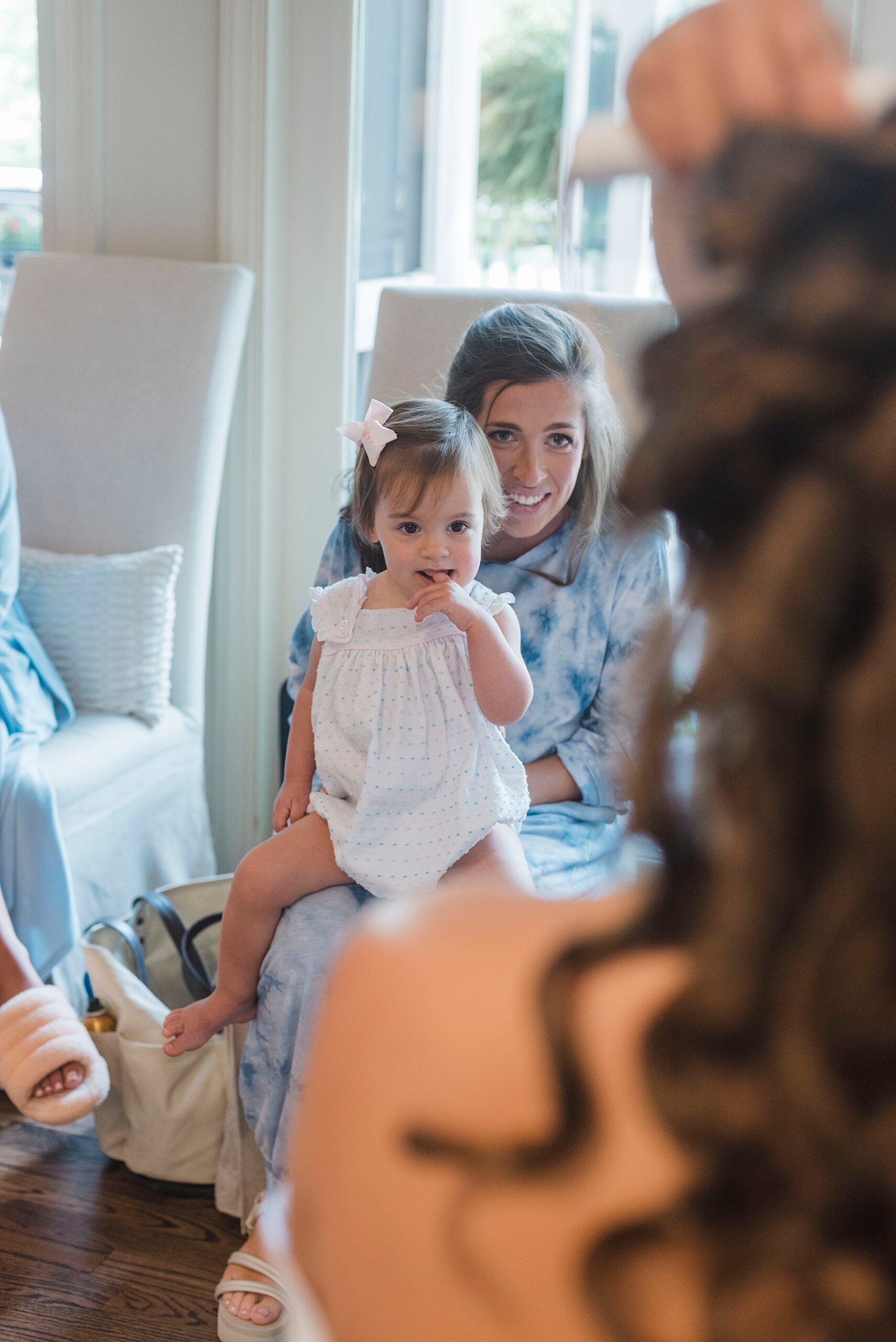woman with little girl watching bride get hair done