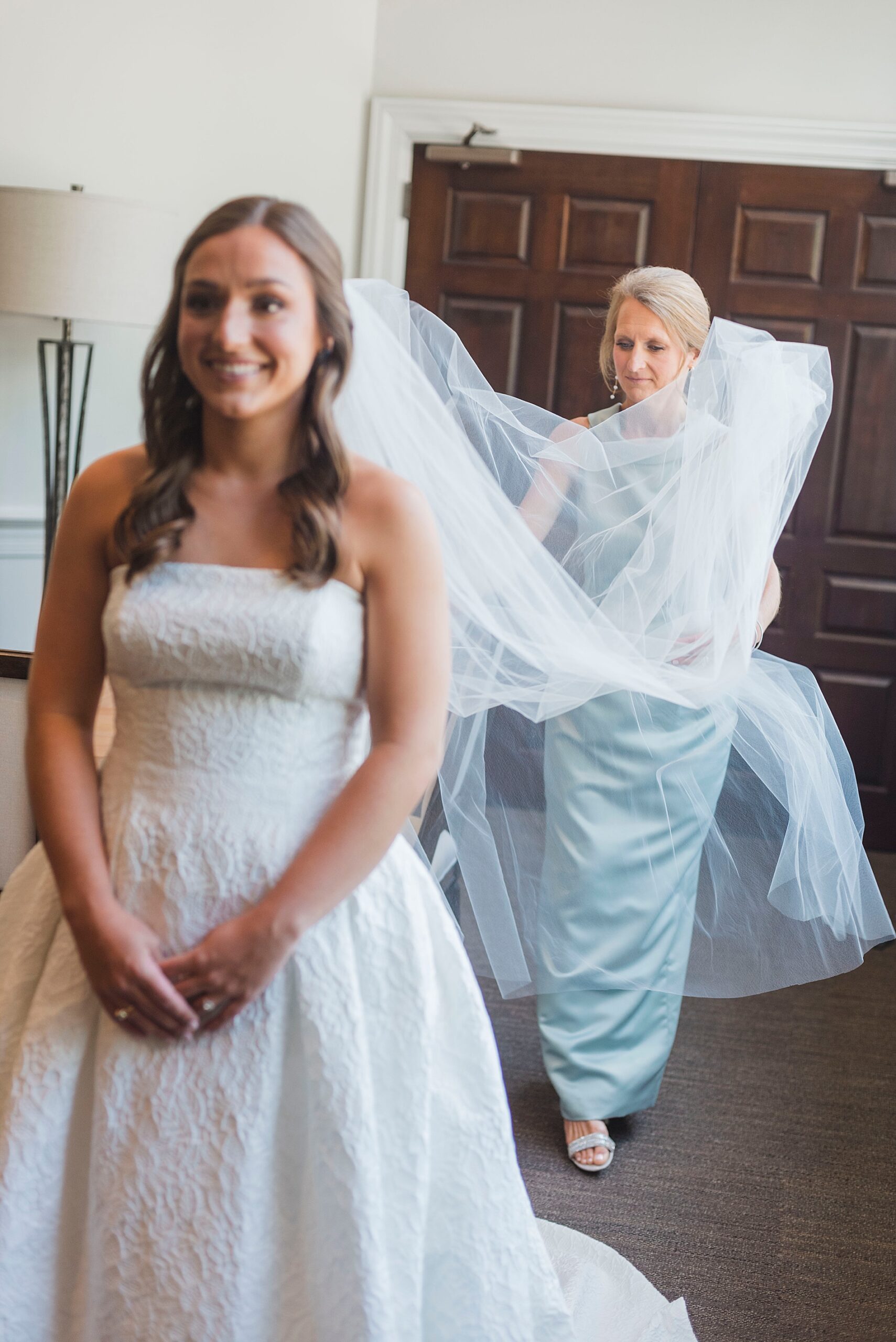 bride puts veil on and mom helps
