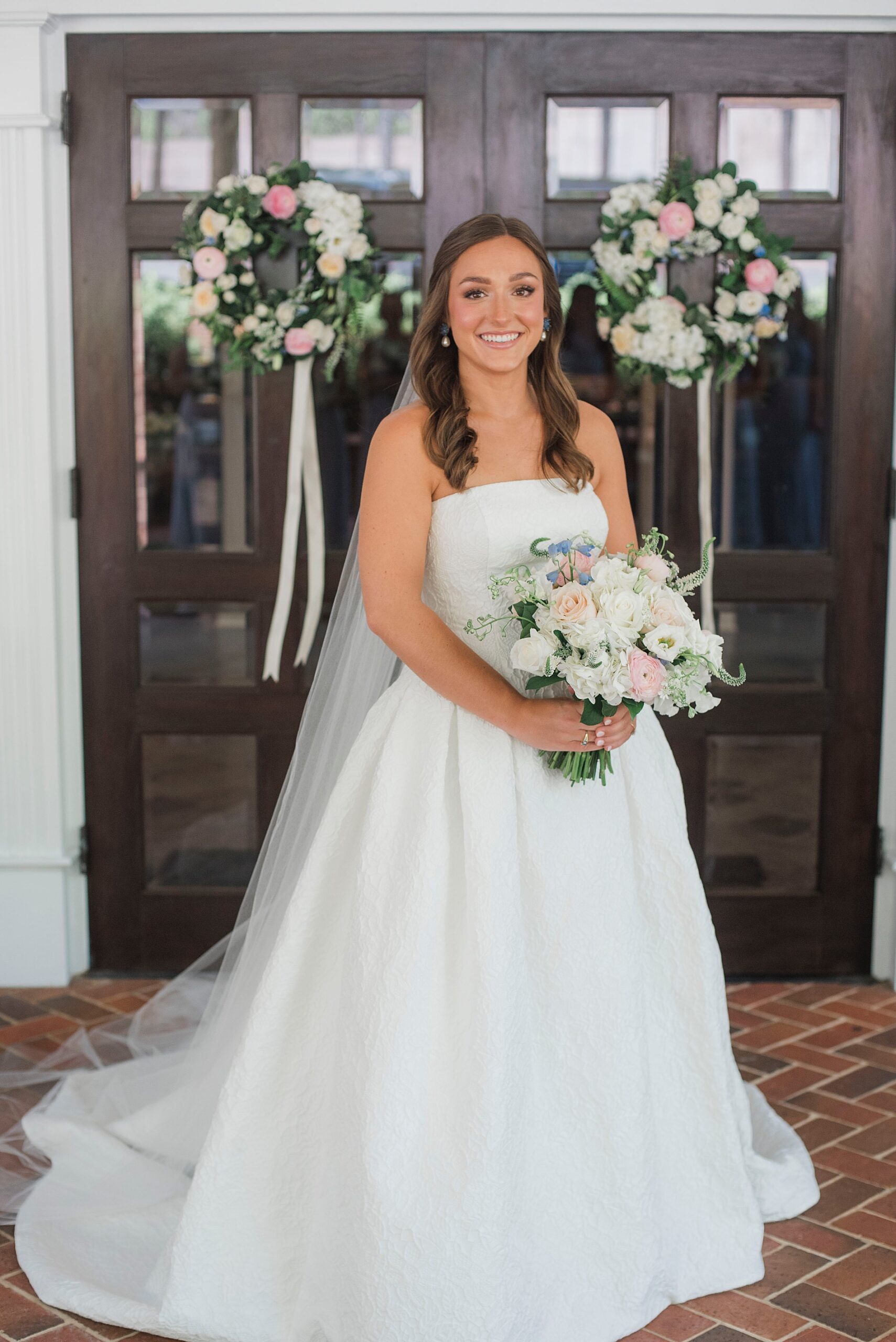 Bride in gown holding romantic bridal bouquet of white and pink flowers