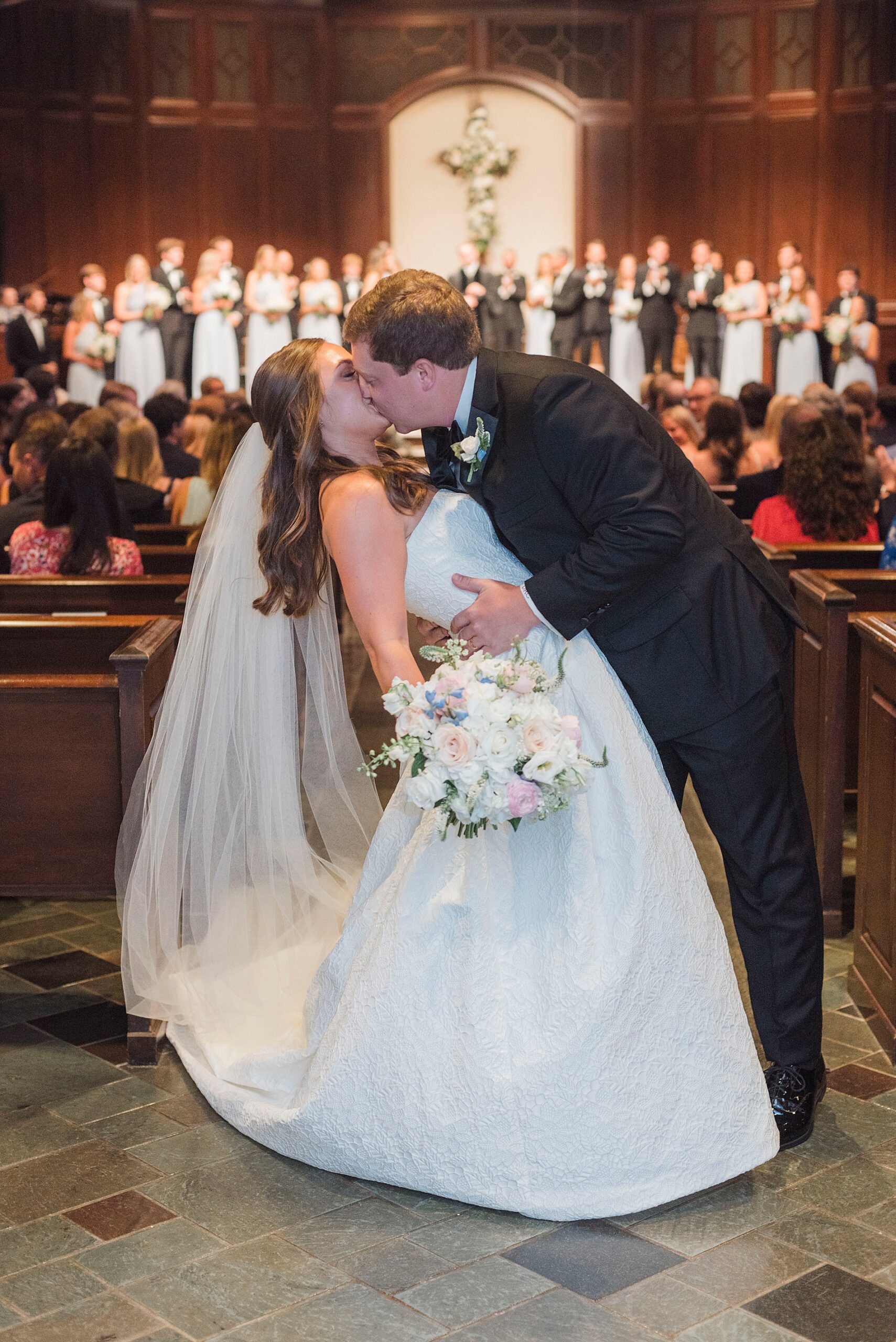 newlyweds kiss at the end of aisle
