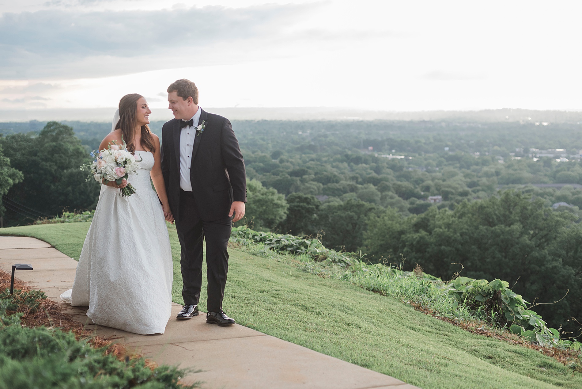 Bride and groom hold hands as they walk together during wedding photos
