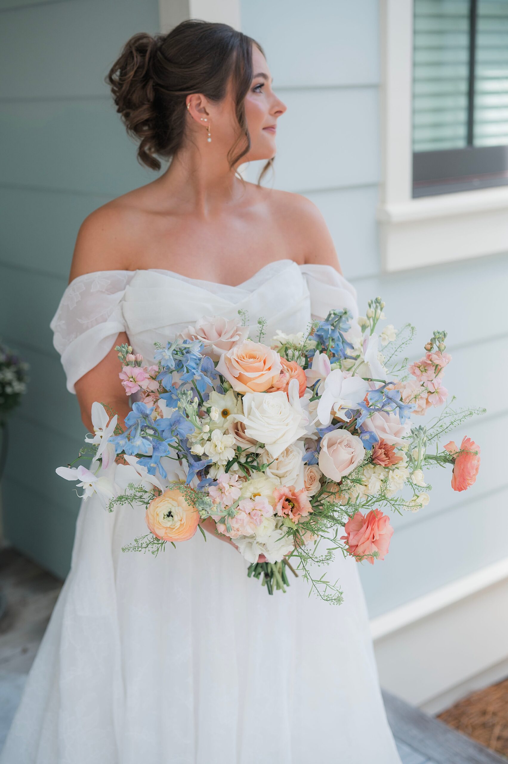bride in strapless wedding dress holding soft floral bridal bouquet