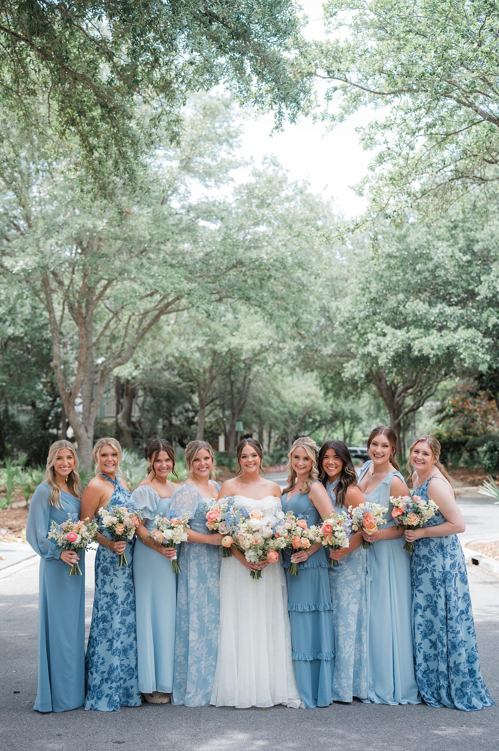 bridesmaids in soft blue bridesmaid dresses surround bride