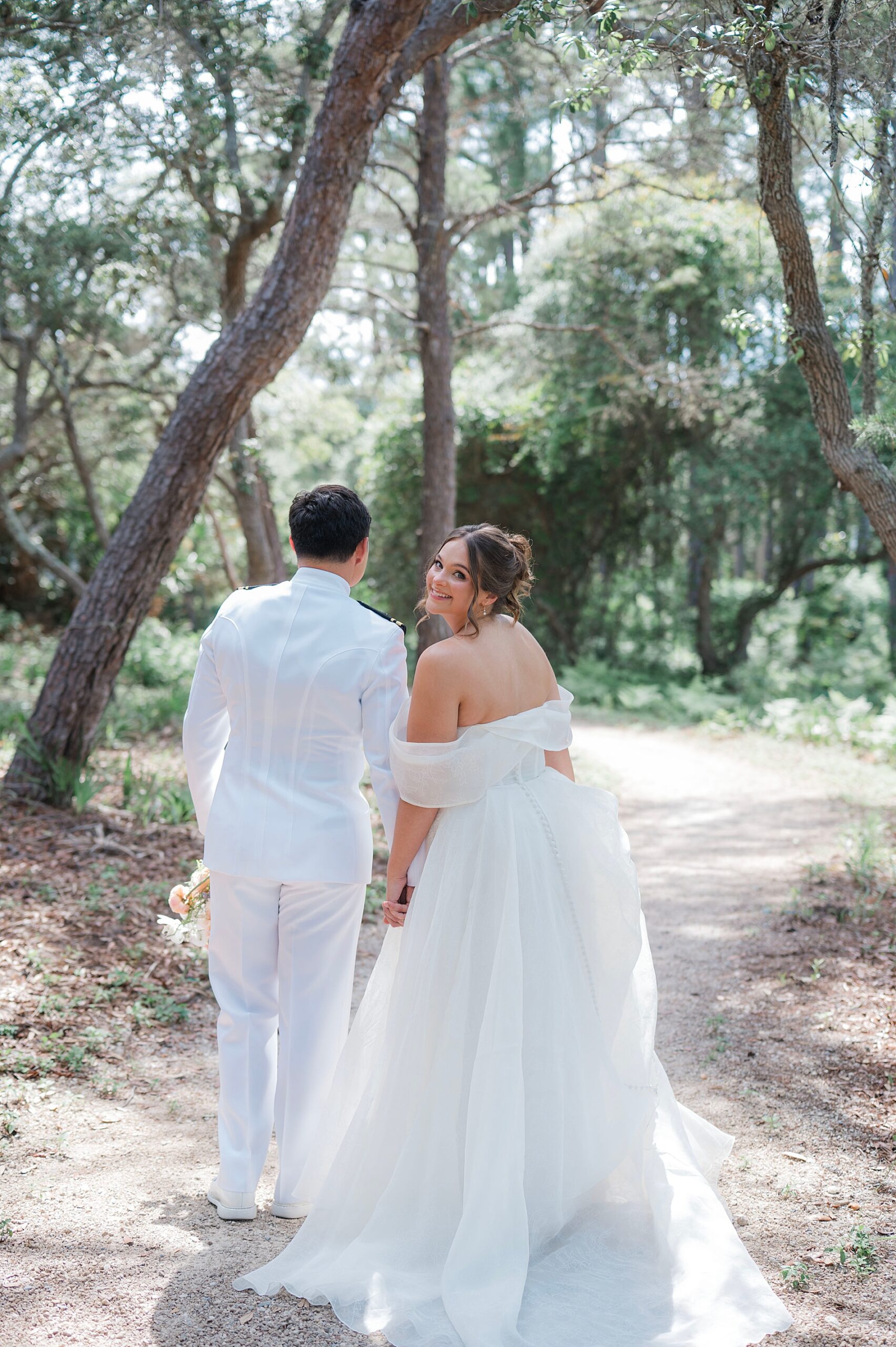 bride turns to look back at camera as she walks with groom