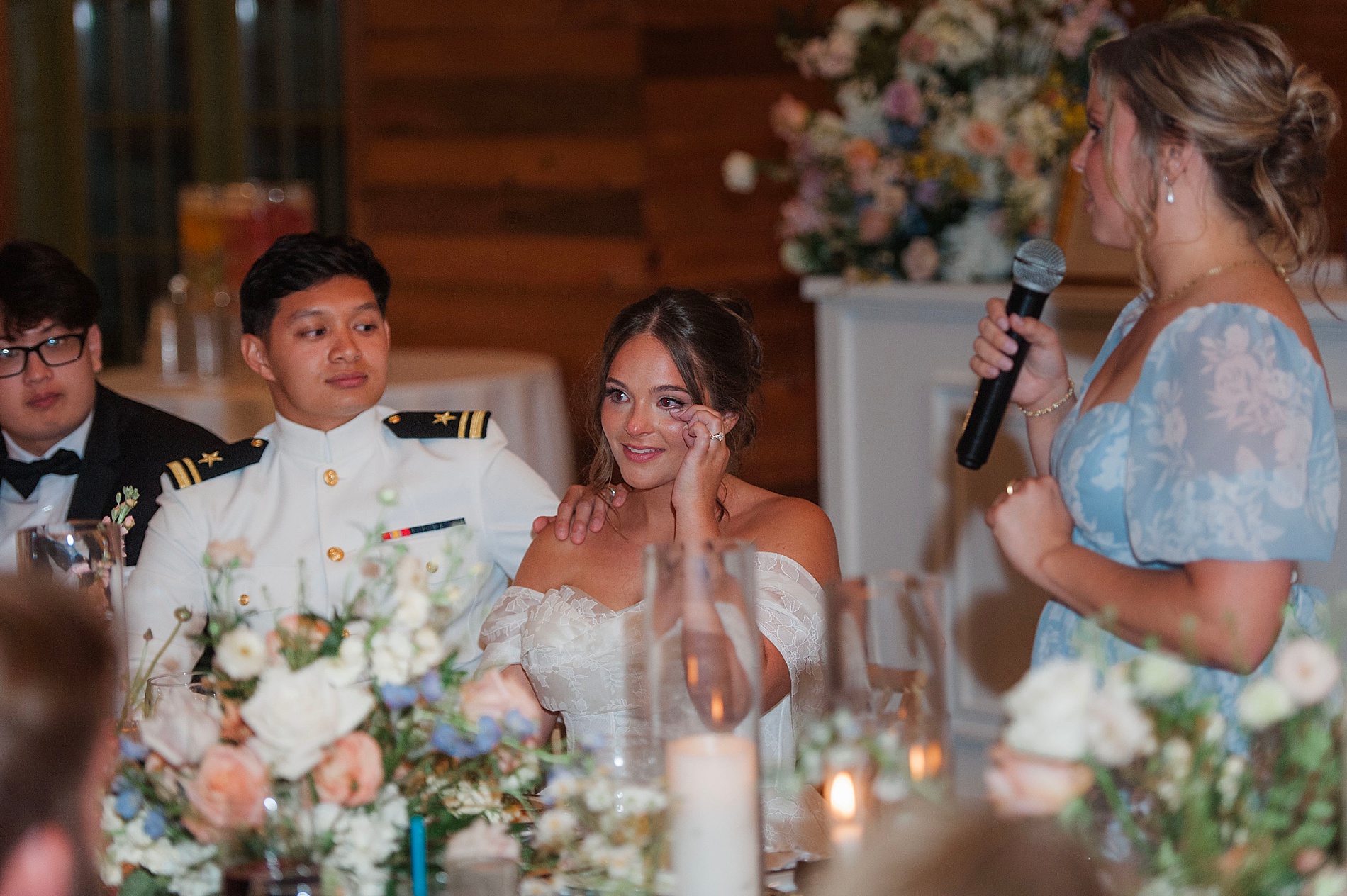 bride wipes away tear during wedding speech