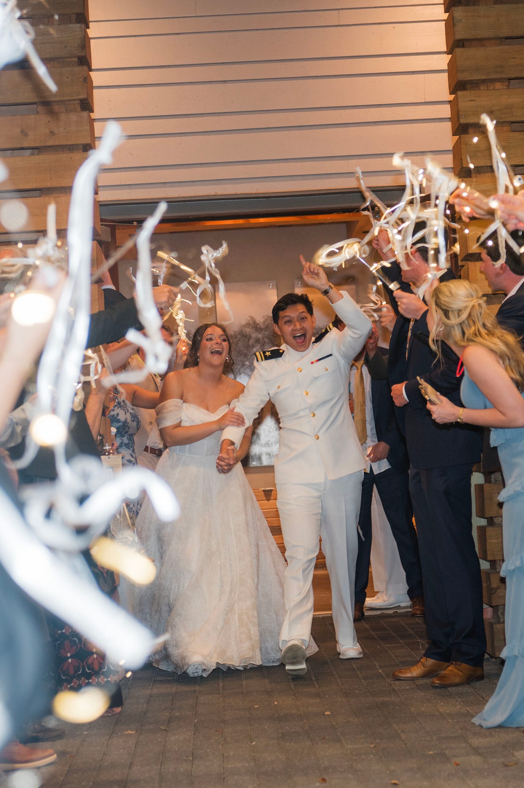 guests wave streamers as newlyweds exit wedding reception