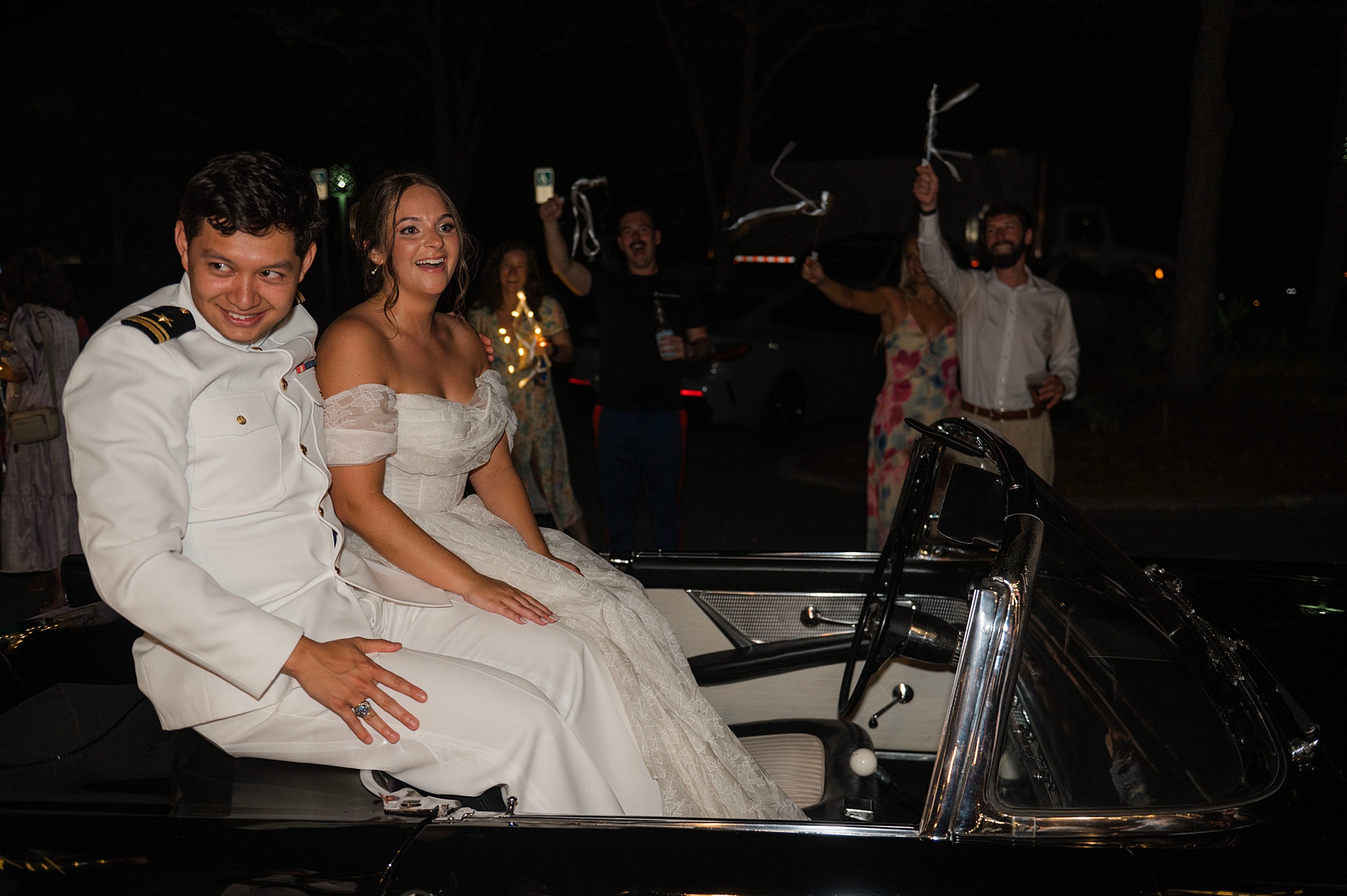 bride and groom sir on back of convertible