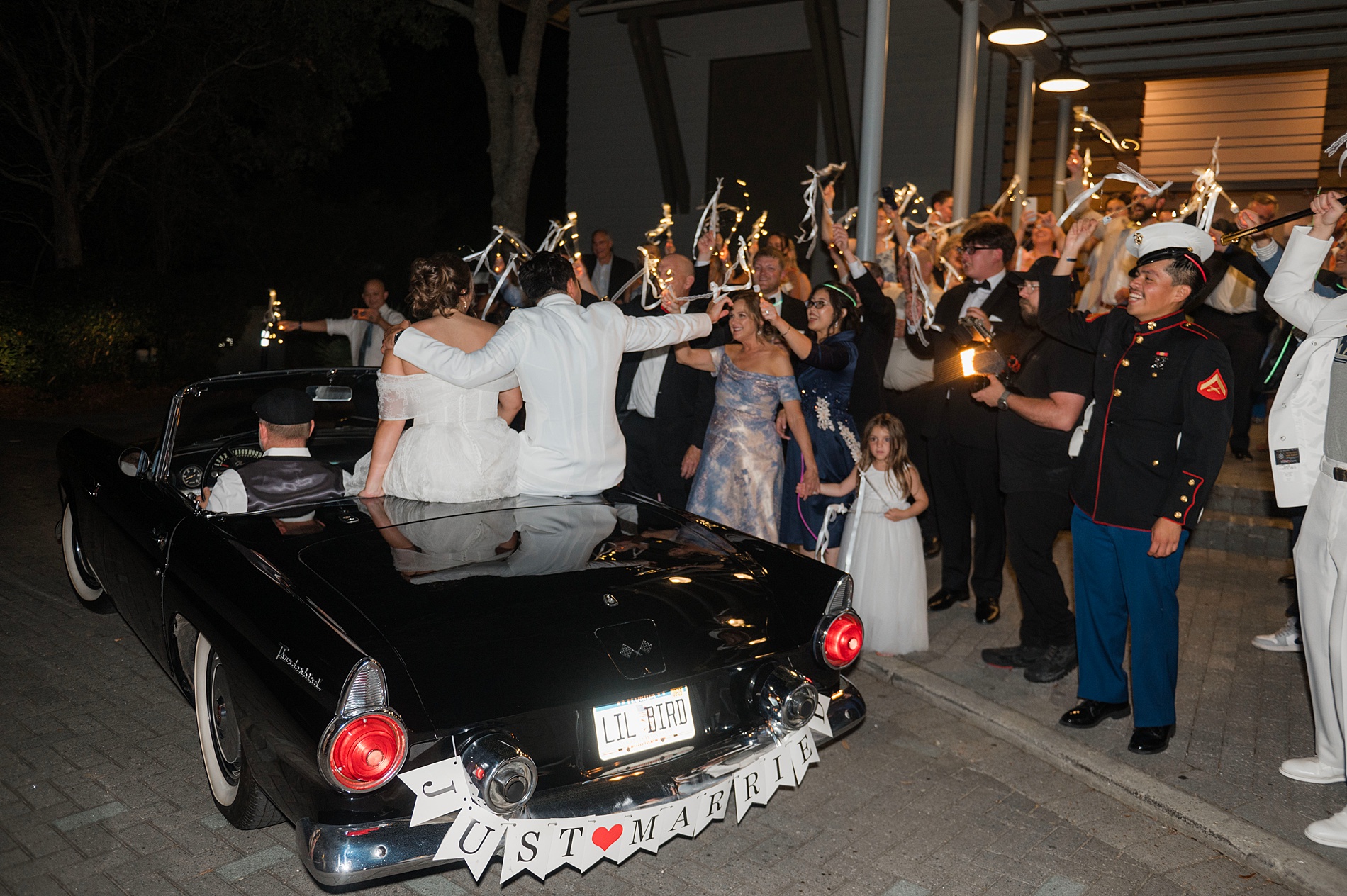 newlyweds wave to guests as they exit in getaway car