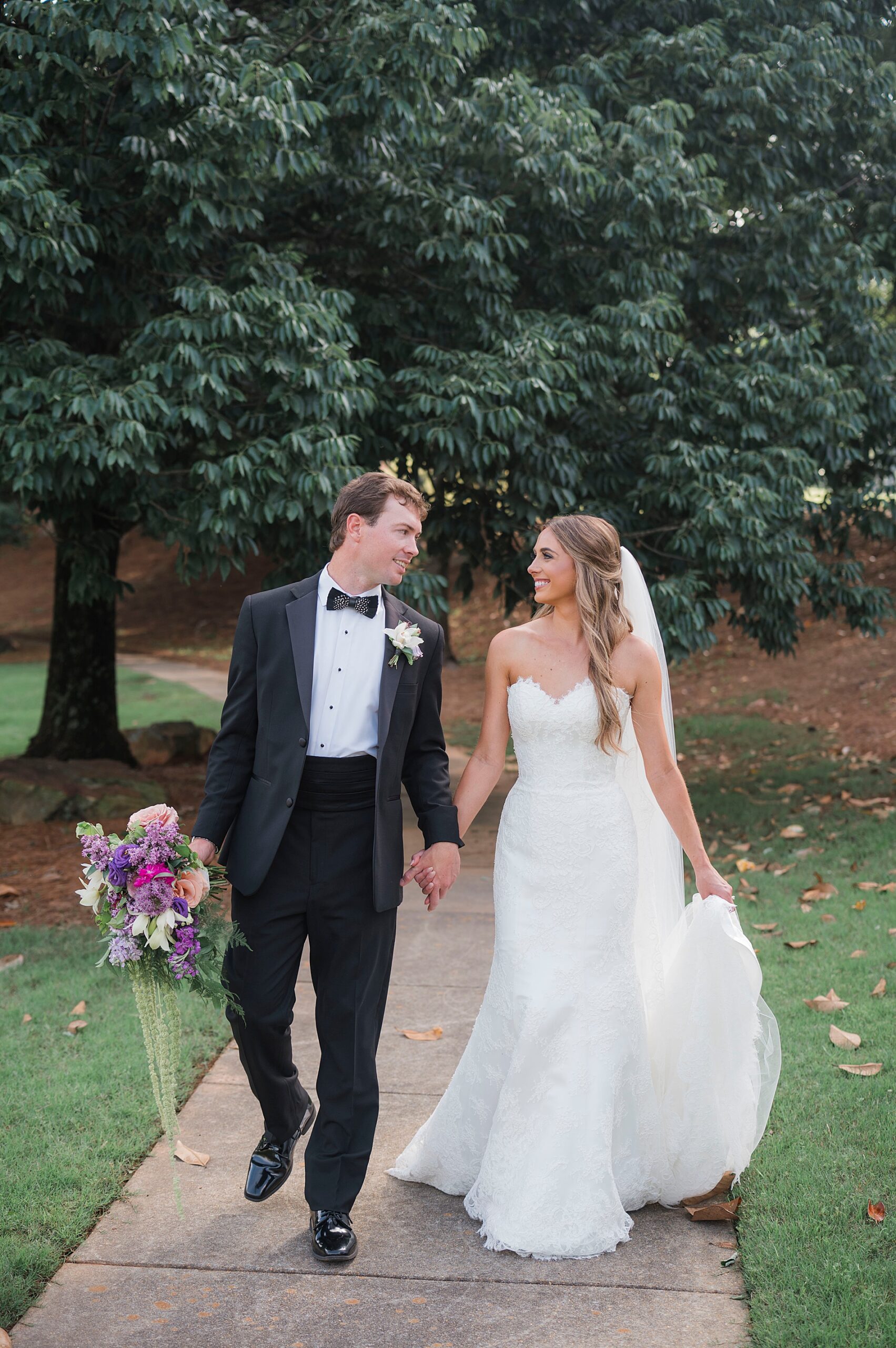 bride and groom hold hands as they walk together