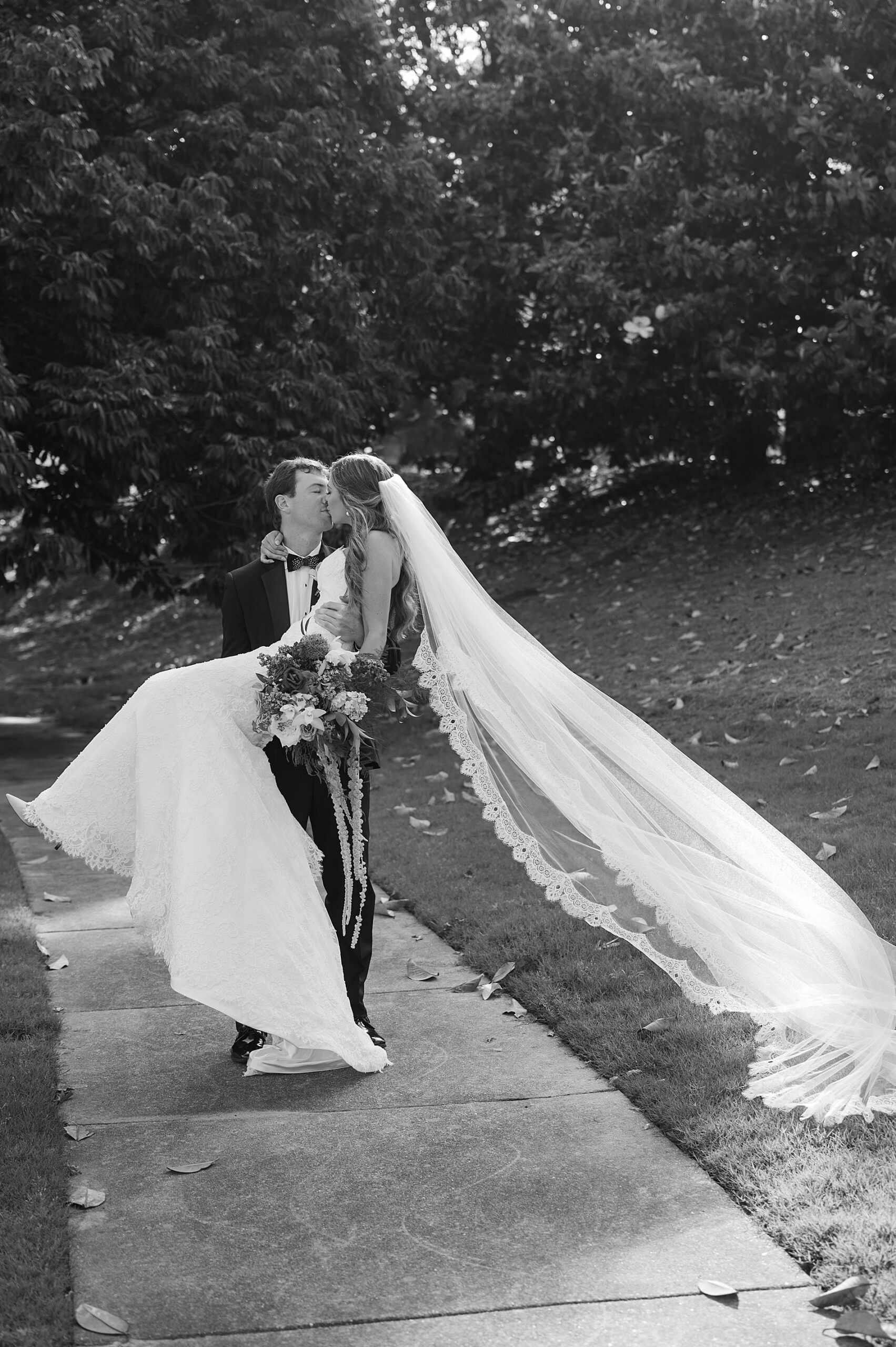 romantic wedding portraits of groom picking up bride in his arms