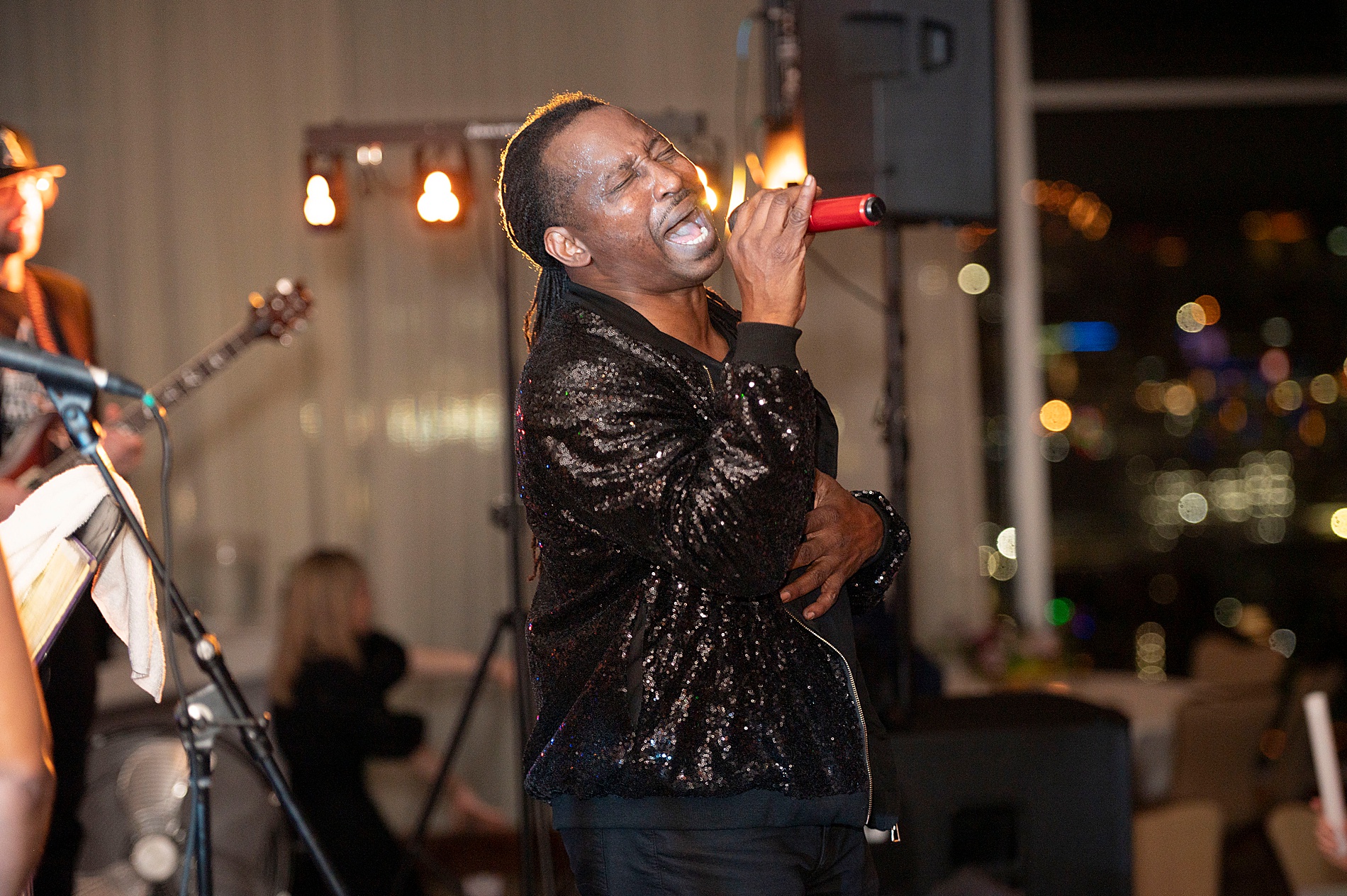 band member sings during reception performance at Elegant Spring Wedding at The Club