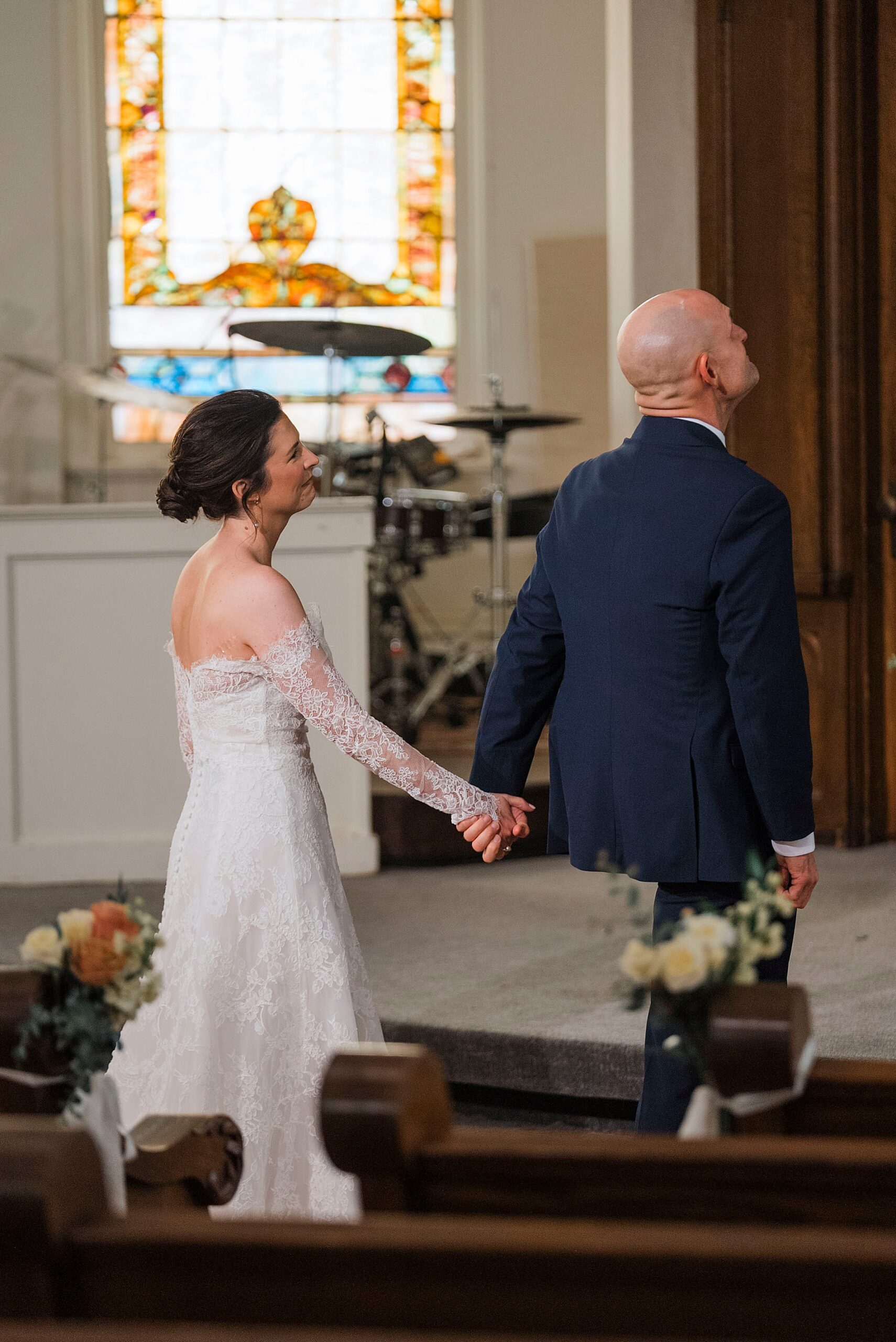 bride touches groom hand moments before he turns around for first look