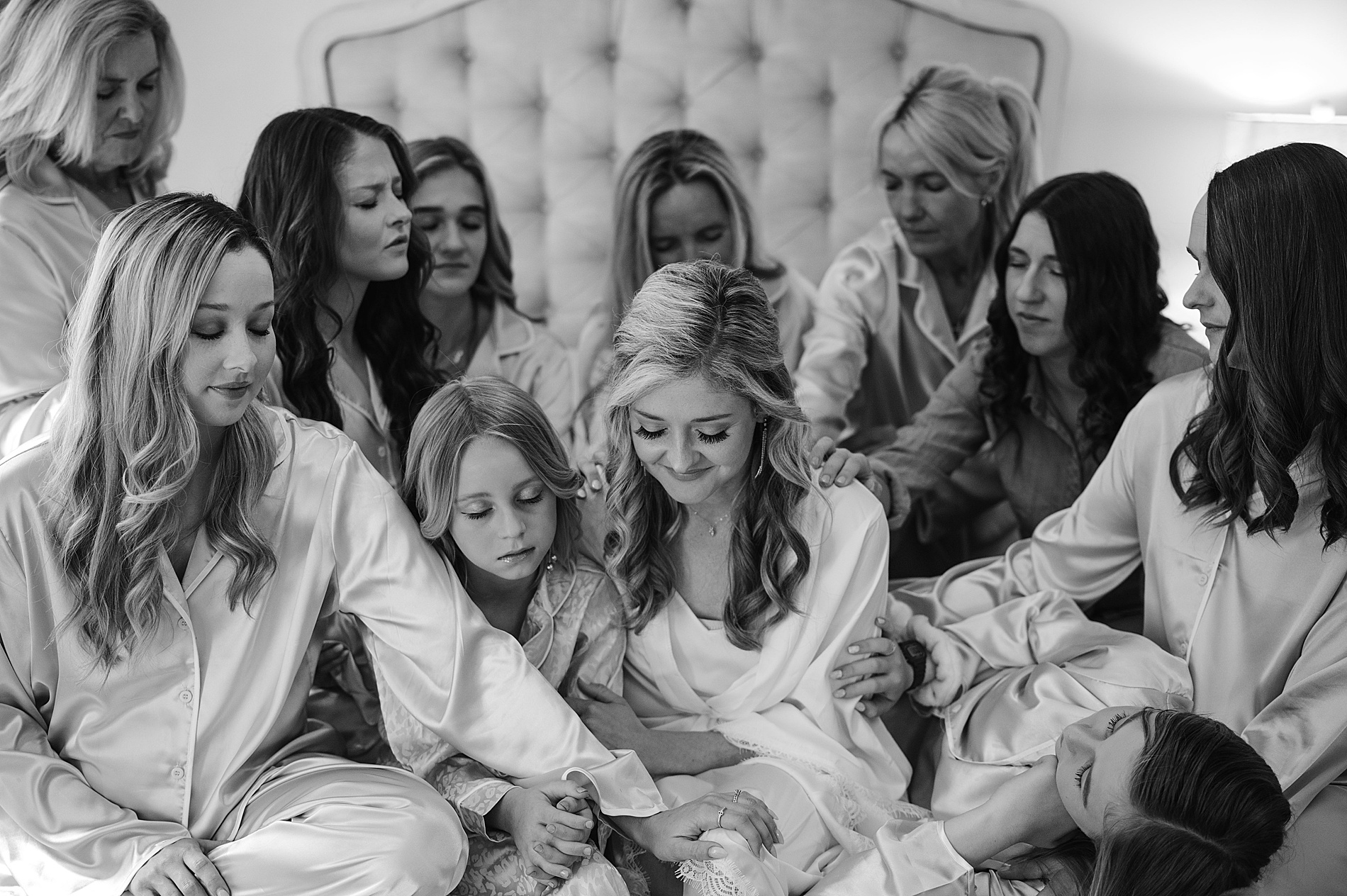 bridesmaids pray with bride the morning of her wedding 
