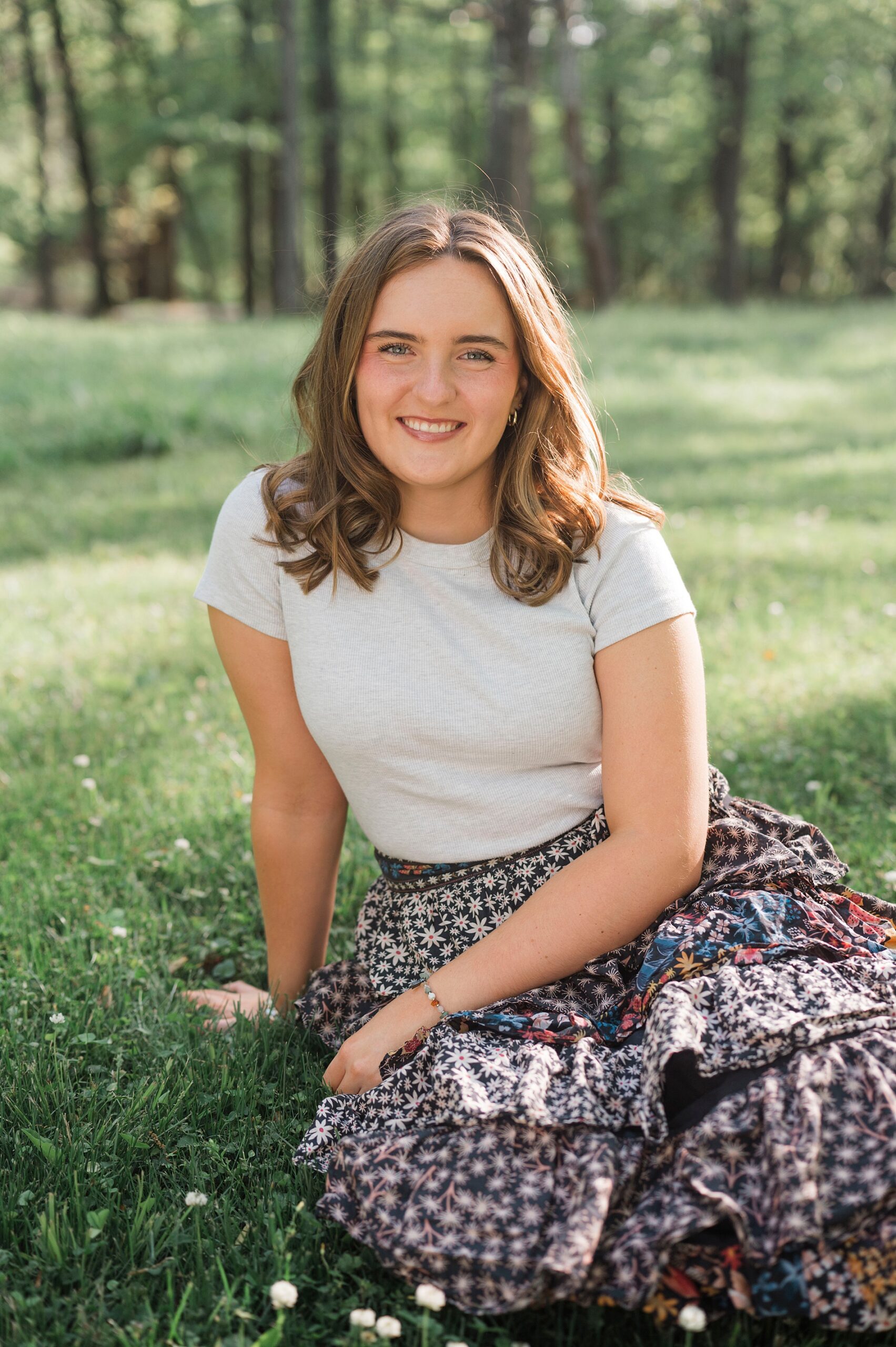 senior girl sits on ground 