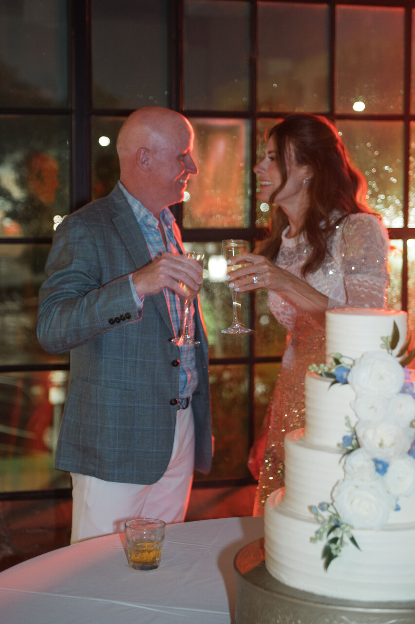 bride and groom toast by wedding cake