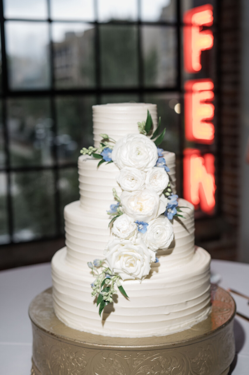 white wedding cake with floral details that match the florals throughout the wedding