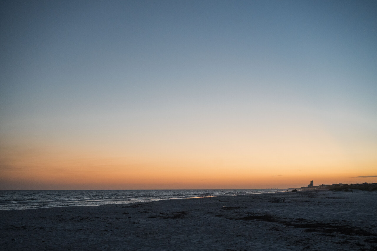 sunset over the water on the beach 